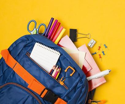 Na żółtym tle niebieski plecak z różnymi przyborami szkolnym tj. : nożyczki, kredki, ołówek, notes, temperówka, długopis, mazaki