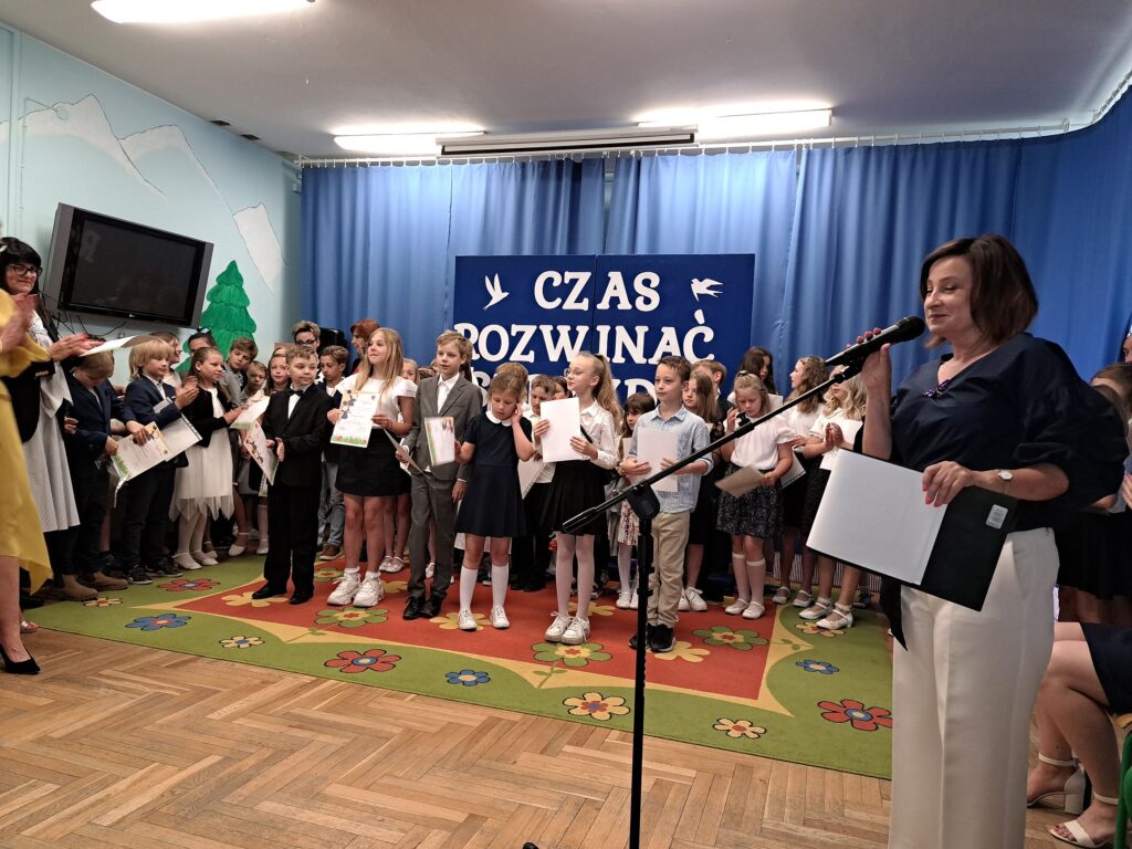 Klasy trzecie oczekują na kolejny punkt uroczystości zakończenia roku szkolnego zapowiadany przez konferansjera