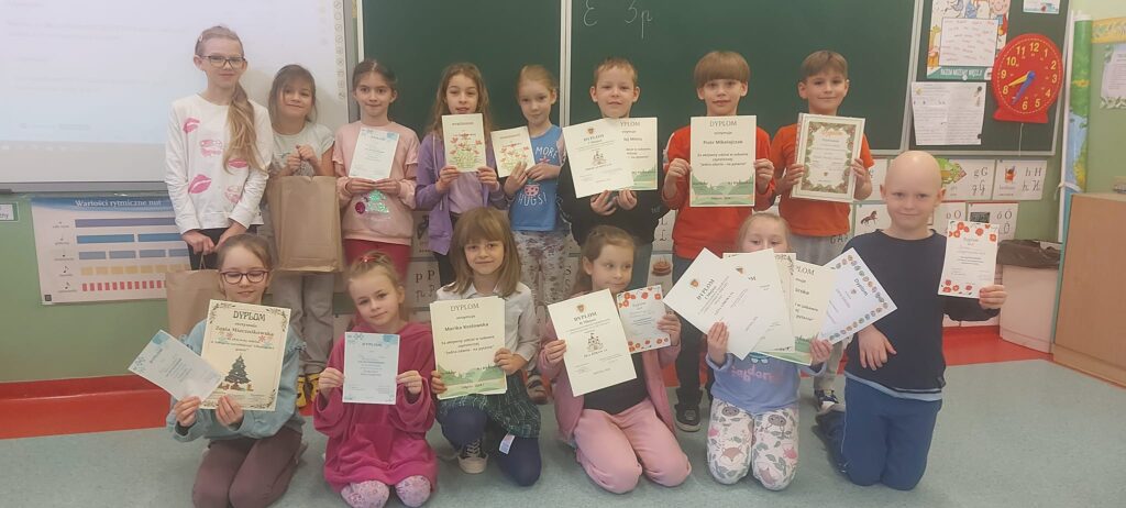 Uśmiechnięci uczniowie z klasy Ia prezentują swoje dyplomy zdobyte za udział w różnych konkursach