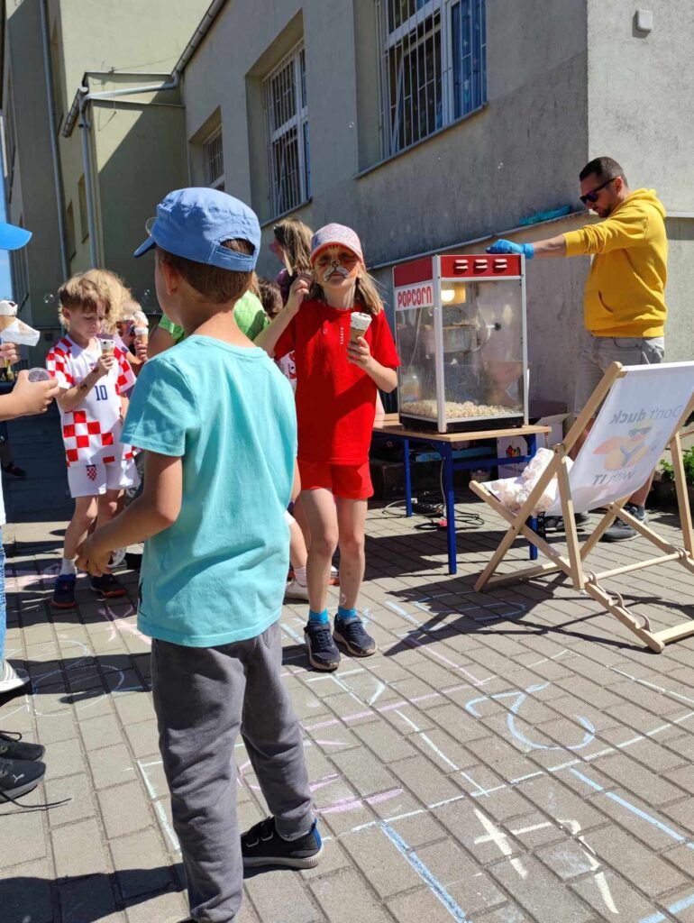 Uczniowie z lodami na placu przy szkole